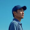 日本人男性ゴルファーが青空を背景にネイビーのゴルフキャップをかぶっている横顔