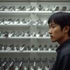 ゴルフ専門店で中古アイアンクラブの棚を眺める日本人男性
