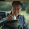 ゴルフカートの小型バッグからゴルフボールを取り出す日本人男性